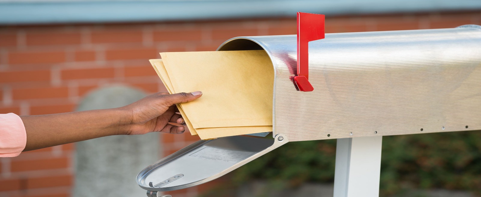 person taking mail out of their mailbox