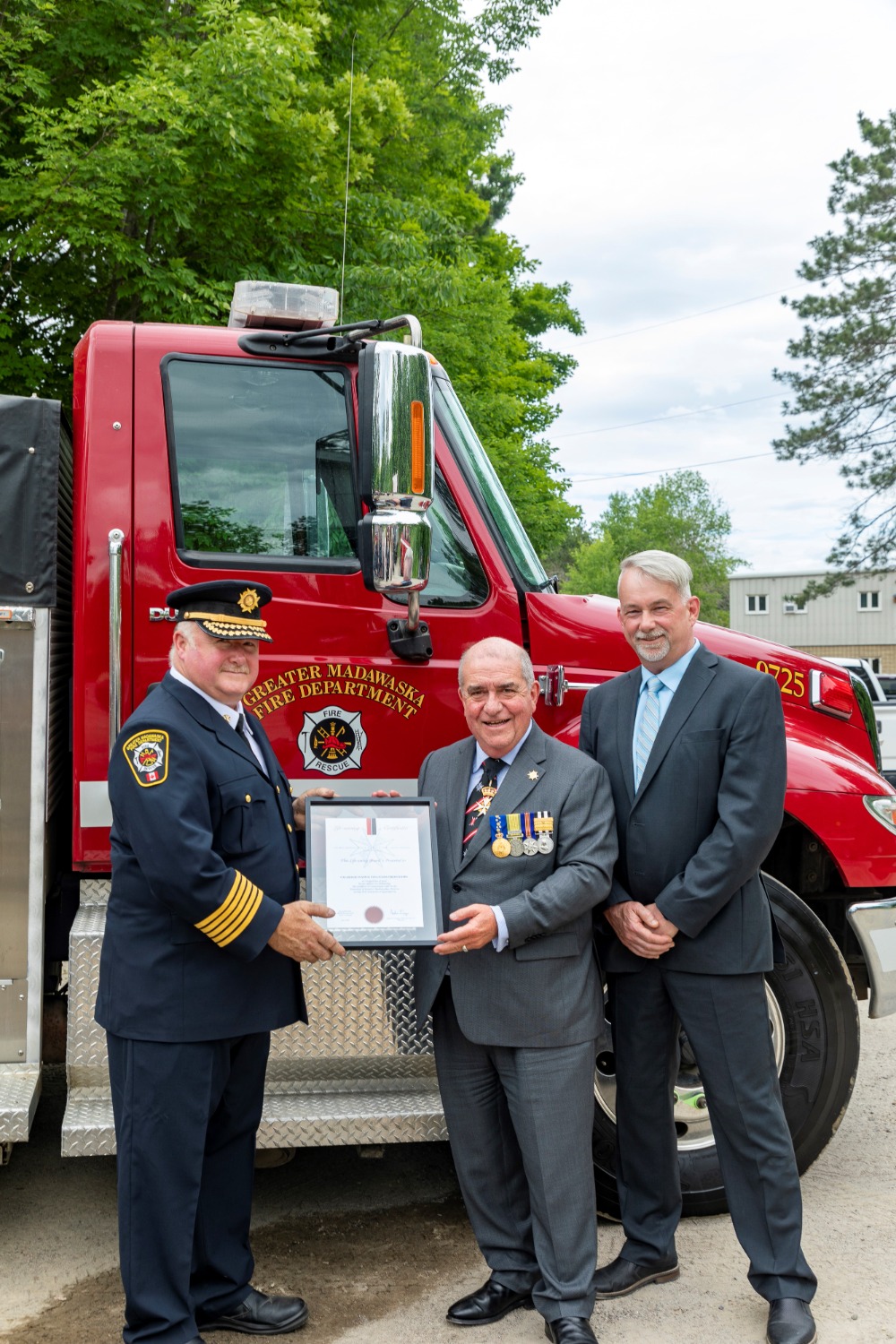 three people standing in front of fire truck