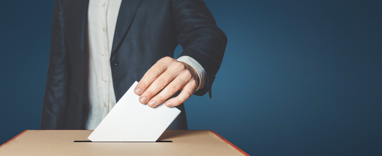 Person dropping a ballot in a ballot box